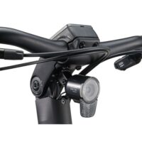Close-up of a bicycle handlebar with a mounted front LED light and attached cables, including a USB-C connector visible on the right.