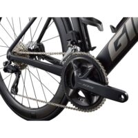 Close-up of a road bike's drivetrain: chain, cassette, and Shimano 105 crank on a black frame with aero wheels.