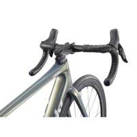 Close-up of a road bike handlebar and front wheel; drop bars with black tape, integrated brake levers, and a LANGMA frame.