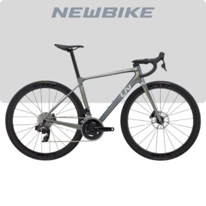 Road bike with aero-gray-green frame, drop handlebars, disc brakes, and a 2x11 drivetrain; branded 'NEWBIKE' backdrop.