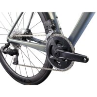 Close-up of a road bike drivetrain: SRAM Rival crankset, front derailleur, chain, and rear cassette on a gray frame.