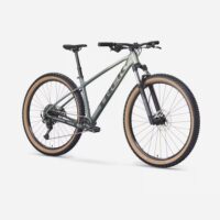 Trek olive-green hardtail mountain bike with beige knobby tires, front suspension fork, and a 1x drivetrain.