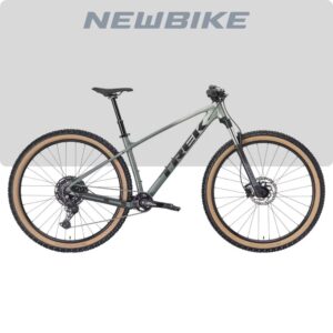 New mountain bike with olive-gray frame, tan-wall tires, and disc brakes, shown in side view with 'NEWBIKE' branding above.