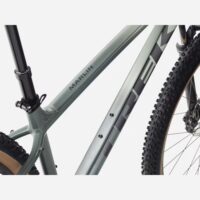 Close-up of a light gray Marlin mountain bike frame showing branding, rear suspension, and partially visible tire and wheel.