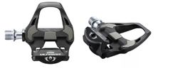 Pair of black clipless bicycle pedals with silver axles, shown from side and top angles.