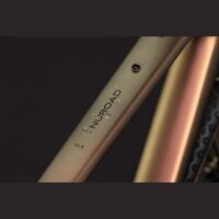 Close-up of a matte olive bicycle frame tube with the NIUROAD branding and small yellow stars, model SLX, size M.