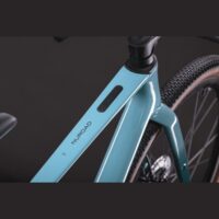 Close-up of a light blue Nurroad bicycle frame with a black rectangular display on the downtube and the rear wheel partially visible.