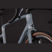 Close-up of a light blue speckled road bike frame at the head tube and front fork with tanwall tires.